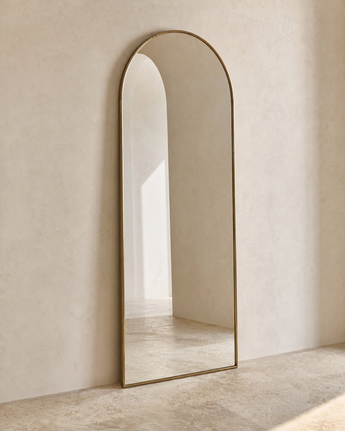 Tall arched mirror with a slim antique brass frame