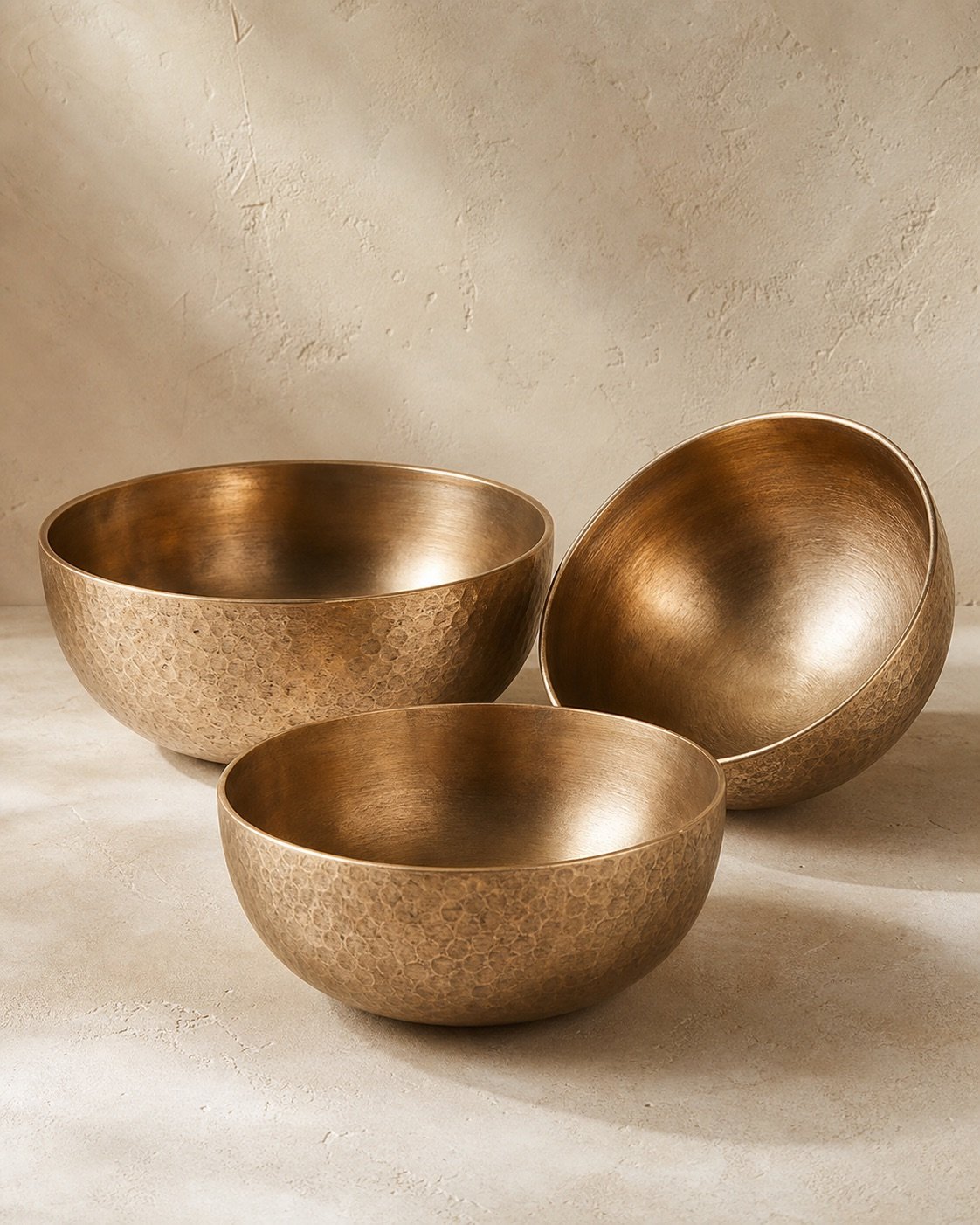 Three nested kansa bronze serving bowls on a dining table